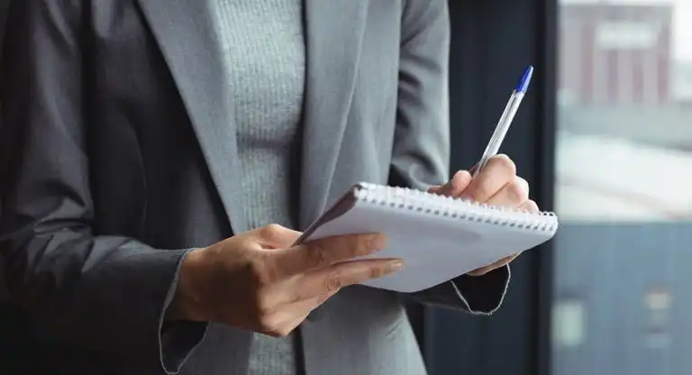 Woman writing in notepad
