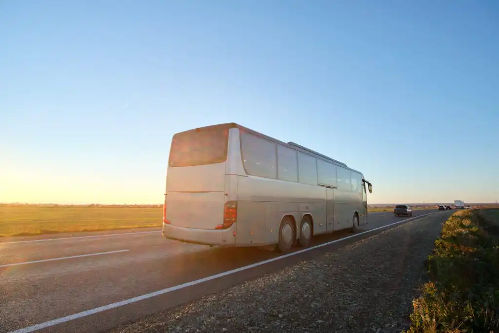Tour bus on highway at sunset