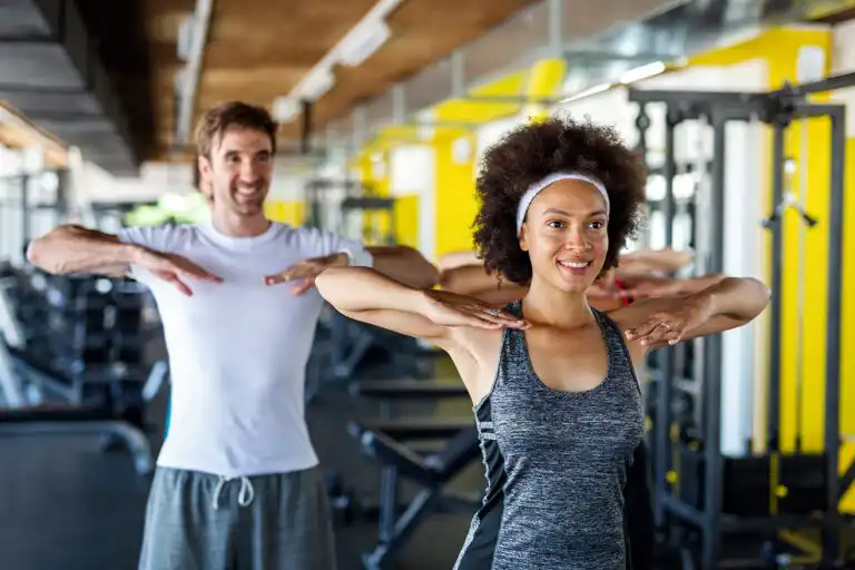 Couple stretching in gym