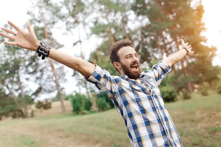 Man with arms outstretched outdoors