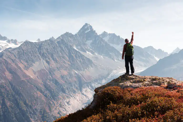 Hiker celebrates mountain summit achievement.