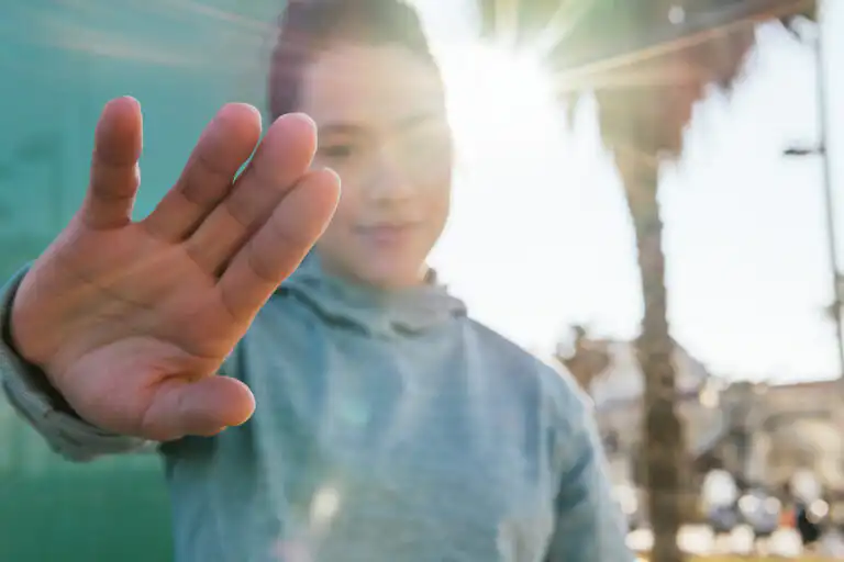 Young person stops with hand
